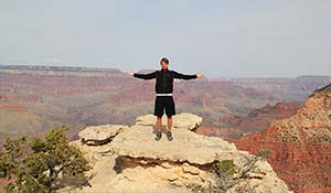 Un turista felice sul punto di osservazione nel Grand Canyon meridionale.