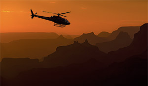 Elicottero in volo sul Grand Canyon al tramonto.